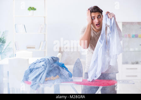 Unaufmerksam Mann brennende Kleidung beim Bügeln Stockfoto