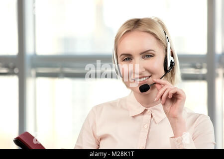 Ziemlich weiblich Customer Support Executive auf Kunden anzurufen. Weibliche Kundenservice Berater operator in Call Center helle Büro. Berühren Headset. Stockfoto