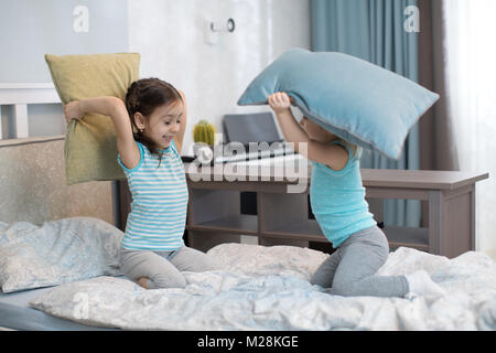 Kleine Kinder Mädchen kämpfen mit Kissen im Schlafzimmer Stockfoto