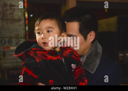 (180206) - SHISHI, Februar 6, 2018 (Xinhua) - Huang Hailong hält seinen jüngeren Sohn vor dem Abflug in Shishi Stadt im Südosten der chinesischen Provinz Fujian, Feb 2, 2018. Huang Hailong, ein Wanderarbeitnehmer aus Suining Stadt von Südwesten Chinas Provinz Sichuan, wurde in einer Kleiderfabrik in Shishi für zehn Jahre gearbeitet. Obwohl das Leben mit seiner Frau und dem jüngeren Sohn Cong Cong, Huang fehlt noch seine Eltern und ältester Sohn, der bergigen Gegend von Sichuan leben. In diesem Jahr, um Geld zu sparen, Huang beschlossen allein in seine Heimatstadt zurückzukehren, das Frühlingsfest mit seiner Familien in Sichuan zu verbringen. (Xi. Stockfoto