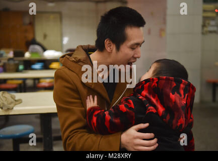 (180206) - SHISHI, Februar 6, 2018 (Xinhua) - Huang Hailong spielt mit seinem jüngeren Sohn vor einer reunion Dinner in Shishi Stadt im Südosten der chinesischen Provinz Fujian, Feb 1, 2018. Huang Hailong, ein Wanderarbeitnehmer aus Suining Stadt von Südwesten Chinas Provinz Sichuan, wurde in einer Kleiderfabrik in Shishi für zehn Jahre gearbeitet. Obwohl das Leben mit seiner Frau und dem jüngeren Sohn Cong Cong, Huang fehlt noch seine Eltern und ältester Sohn, der bergigen Gegend von Sichuan leben. In diesem Jahr, um Geld zu sparen, Huang beschlossen allein in seine Heimatstadt zurückzukehren, das Frühlingsfest mit seiner Familie zu verbringen Stockfoto