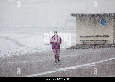 Llandudno, Wales, 6. Februar 2018. UK Wetter. Als eine gelbe Warnmeldung für Schnee für North Wales heute mit einigen Teilen von bis zu 8 cm auf höheren Boden vorhergesagt. Sehr ungewöhnlichen Schnee für die Seebad Llandudno im Norden von Wales als diese Person entdeckt Joggen entlang der Strandpromenade proemenade Â© DGDImages/Alamy leben Nachrichten Stockfoto