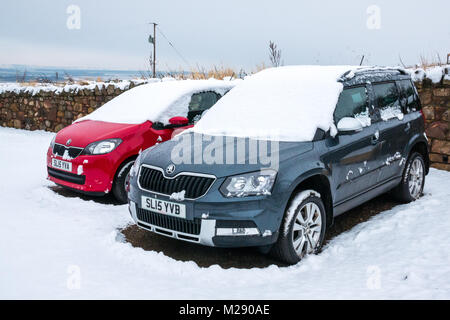 East Lothian, Schottland, Vereinigtes Königreich. Ein kalter Morgen mit ein paar Zentimeter Schnee auf Autos, wenn die Besitzer ging am Morgen. Ein roter SKODA Citigo und ein blauer Skoda Yeti 4x4, mit passenden Anzahl Platten Stockfoto