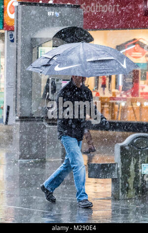 Schneit in Southport, Merseyside. 6. Februar 2018. UK Wetter. Schnee, Regen, auf die Menschen, die in der Innenstadt in Southport, Merseyside.. Leichter Schnee und einige breezy Bedingungen werden über den Nordwesten von England den ganzen Morgen mit einigen helleren Zauber später prognostiziert. Credit: cernan Elias/Alamy leben Nachrichten Stockfoto