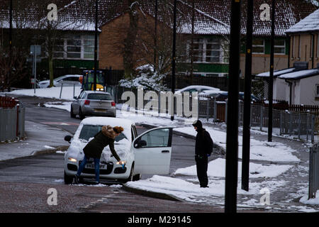 Dundee, Schottland, Großbritannien. 6. Februar, 2018. UK Wetter: eisige Temperaturen bringt über Nacht Schnee über Nordostschottland. Eine Frau, die den Schnee vom Kratzen ihr Auto im Ardler Dorf Wohnsiedlung in Dundee, UK: Credits: Dundee Photographics/Alamy leben Nachrichten Stockfoto