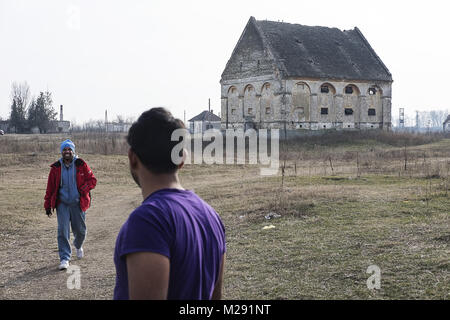 Horgos, Kanjiza, Serbien. 27 Jan, 2018. Migranten aus Pakistan Spaziergang, vorbei an einem großen Gebäude waren Sie leben in der Nähe der serbisch-ungarischen Grenze. Horgos ist ein Dorf in Kanjiza Gemeinde befindet sich im nördlichen Banat Bezirk von Serbien, weniger als 10 km von der serbisch-ungarischen Grenze. Die balkanroute wurde offiziell vor über einem Jahr mit Kroatien und Ungarn Erhöhung der Sicherheit der Grenzen, die Migranten und Flüchtlinge in Serbien klemmt geführt hat geschlossen. Während die Grenzen um Serbien angezogen haben, gibt es immer noch versucht, die Grenzübergänge jede Nacht. Migranten aus Pakist Stockfoto