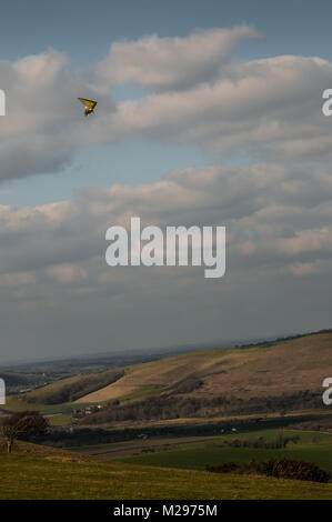 Firle Beacon. East Sussex. Februar 2018. Wetter in Großbritannien. Hardy erfahrene Hansegler-Piloten nutzen den kalt vorherrschenden Nordwind über die South Downs in der glorreichen Landschaft von Sussex. Stockfoto