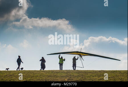 Firle Beacon. East Sussex. Februar 2018. Wetter in Großbritannien. Hardy erfahrene Hansegler-Piloten nutzen den kalt vorherrschenden Nordwind über die South Downs in der glorreichen Landschaft von Sussex. Stockfoto