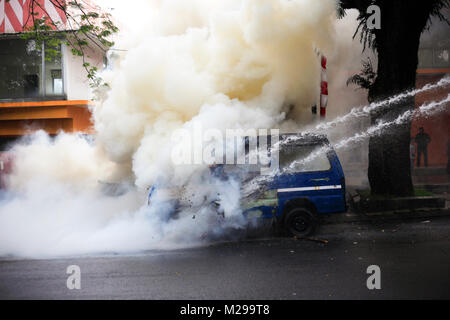 Bogor, West Java, Indonesien, 3. Februar 2018. Polizisten löschten die Feuer auf ein Auto, das durch Demonstranten während einer Simulation der Sicherheit der lokalen Wahlen, Bogor, West Java, Indonesien, 3. Februar 2018 verbrannt wurde Stockfoto