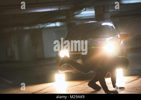 Man Acrobat zeigt Tricks Salto in der Tiefgarage Stockfoto