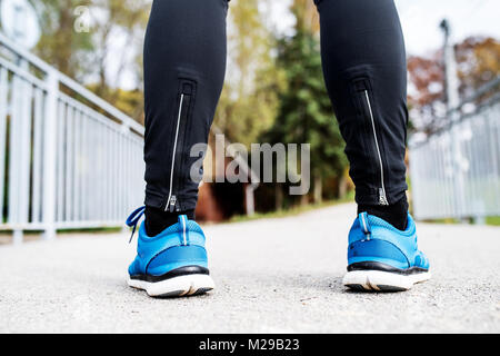 Beine von junger Läufer stehen auf Asphalt weg. Stockfoto