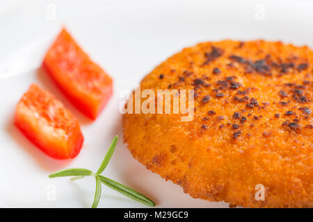 Nahaufnahme von Hähnchen Cordon Bleu auf Platte mit Rosmarin und rotem Pfeffer Stockfoto