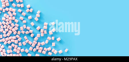 Marshmallows auf blauem Hintergrund mit Copyspace. Flach oder der Ansicht von oben. Hintergrund oder Textur von bunten mini Marshmallows. Winter essen Hintergrund conc Stockfoto