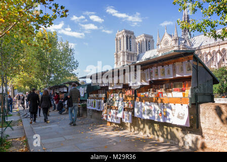 Touristen zu Fuß durch die berühmte Buchhändler Boxen (bouquinistes) entlang der Seine in der Nähe von Notre Dame in Paris, Frankreich Stockfoto