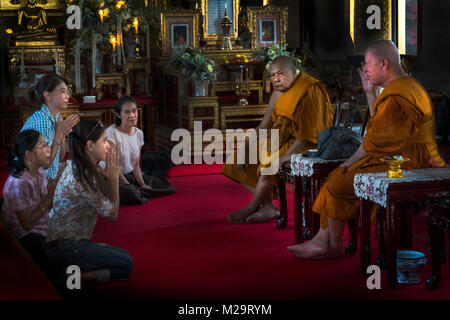 Einige Gläubige vor der buddhistischen Mönche in einem Tempel in Bangkok, Thailand Stockfoto
