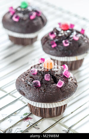 Lustige Schokolade Muffins mit Bonbons eingerichtet. Stockfoto