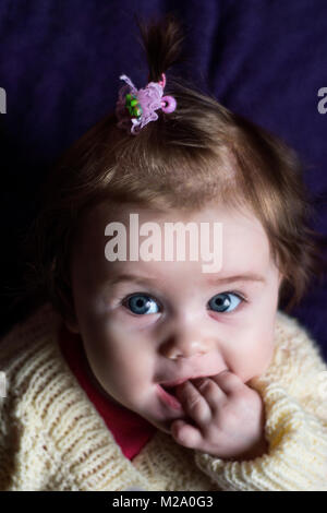 Das Baby fasziniert uns mit ihrem Blick und Lächeln. Stockfoto