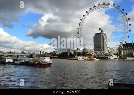 Ein Blick auf das London Eye und die Themse. Bewölkt blauer Himmel im Hintergrund. Stockfoto