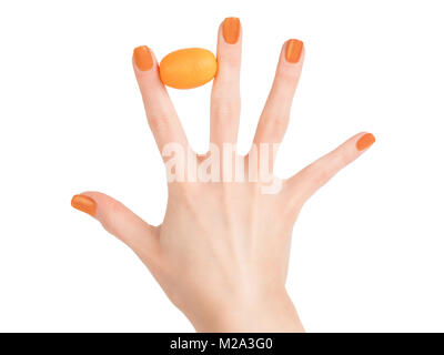 Frau hand mit perfekte Haut und orange Nagellack Holding kleine orangene Zitrusfrüchte zwischen den Fingern. Schönheit Konzept. Auf weiß Isoliert, Clipping Stockfoto