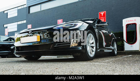 EINDHOVEN, Niederlande - 25 September 2016: Tesla Model S-Motoren Werk in Tilburg, Niederlande. Tesla supercharge Station mit einem Auto auf Cha Stockfoto