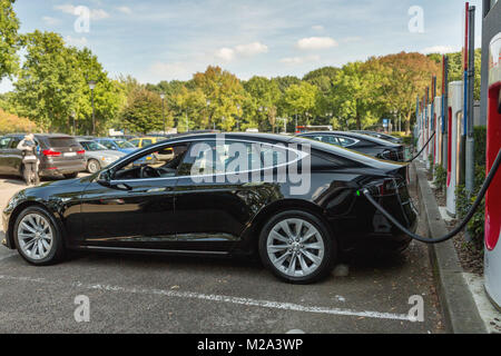 EINDHOVEN, Niederlande - 25 September 2016: Tesla Model S-Motoren Werk in Tilburg, Niederlande. Tesla supercharge Station mit einem Auto auf Cha Stockfoto