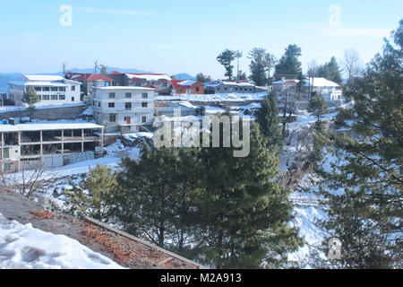 Snowy Mountain mit Häusern und Bäumen. Stockfoto