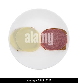 Blick von oben auf die Genua Salami und Provolone Schichten auf Stein Boden Brot aus Weizen auf einem Schild auf einem weißen Hintergrund. Stockfoto