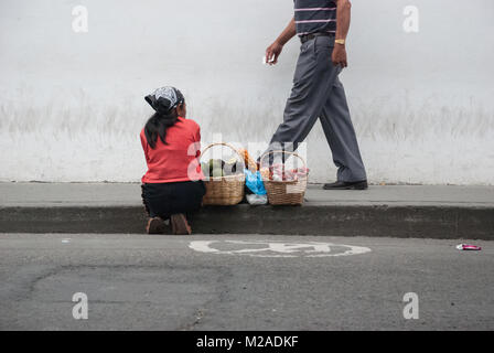 Ein Mann hinter einem weiblichen Street Hersteller auf dem Bürgersteig in Pereira, Kolumbien Stockfoto