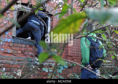 Zwei Männer in einem verlassenen Backsteinlagerhauses durch ein Fenster in Bristol, England Stockfoto