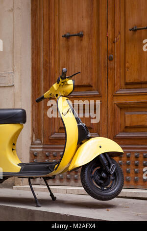 Nur ausreichend Parkplätze für dieses kleine gelbe Motorroller an der Haustür, Montalcino, Toskana, Italien Stockfoto