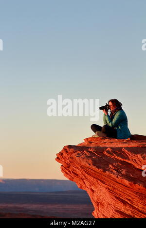 Page, Arizona - Dezember 28, 2016: Fotografin Bilder nimmt mit großer Kamera sitzen auf dem Rand der Klippe im Horseshoe Bend Stockfoto