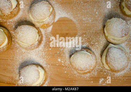 Die traditionelle Fastnacht bun-semla auf einem Schneidebrett mit Zucker bestäubt. Stockfoto