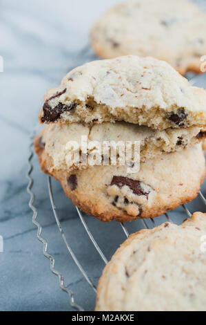Nahaufnahme des in zwei traditionelle Amerikanische hausgemachte Chocolate Chips cookies mit semi-süße Schokolade chunks frisch aus dem Ofen am Kabel Kühlung kaputt r Stockfoto