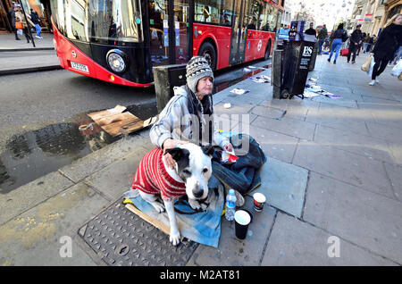 London, England, UK. Obdachloser Mann mit seinem Hund in der Oxford Street Stockfoto