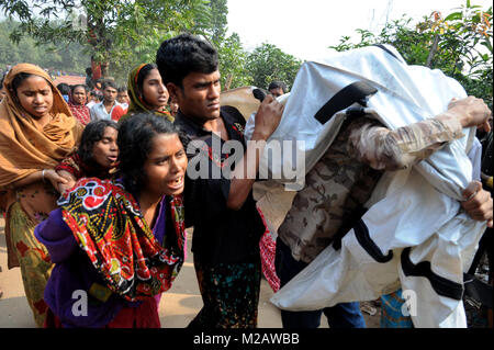 DHAKA, BANGLADESCH - November 25, 2012: Ein Bangladeshi Frau beklagt, während Sie hält den Körper eines Verwandten, der bei einem Brand im Werk gestorben Tazreen Mode Stockfoto