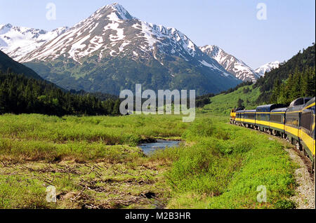 Die wunderschöne schneebedeckte Bergwildnis Alaskas, vom letzten Auto dieses Zuges aus gesehen, auf dem Weg zum Denali National Park. Stockfoto