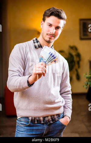 Hübscher junger Mann zählen Geld, drinnen geschossen Stockfoto