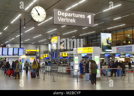 Schilder, Uhr und Reisende im abflugterminal von Amsterdam Airport Schiphol, Niederlande Stockfoto