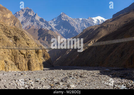 Hängebrücke über eine Schlucht, in die Berge, Himalaya, Nepal Stockfoto