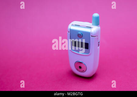 Cool und klassischen Motorola V220 Pink retro flip Zelle oder Handy vor einem roten Hintergrund isoliert Stockfoto