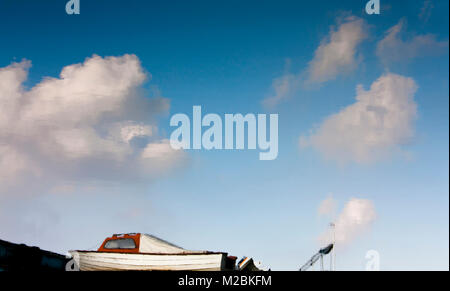 Unscharfe Reflexion verankert kleine Boote, blauer Himmel und Wolken im Wasser des Flusses Stockfoto