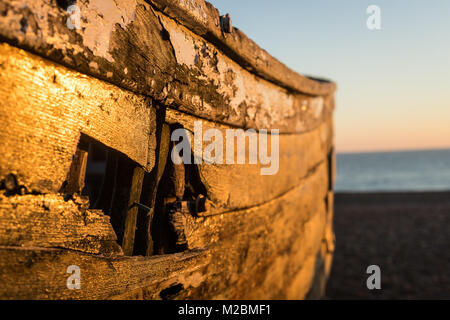 Nahaufnahme von einem alten Boot auf Brighton Strand bei Sonnenuntergang im Winter Stockfoto