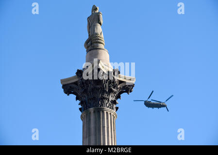 Boeing Chinook Hubschrauber der Royal Air Force fliegt über London vorbei an Admiral Nelson auf der Nelson's Column am Trafalgar Square Stockfoto