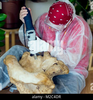 Holzschnitzer mit Brille Schnitzerei aus natürlichen Edelsteinen Holz, Kunst Objekt für die Dekoration von Haus. Hände mit Tools close-up. Konzept der handgefertigten, Professionalität und Hobby Stockfoto