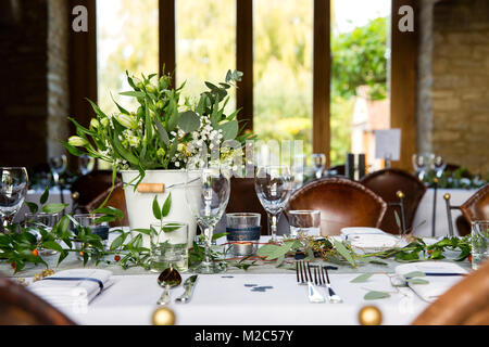 Tabelle mit Einstellungen, Blumenschmuck und Glaswaren Stockfoto