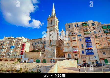 Valletta, Malta - St. Paul's Anglican Turm der Kathedrale zwischen den Häusern, vom Hafen gesehen. Stockfoto