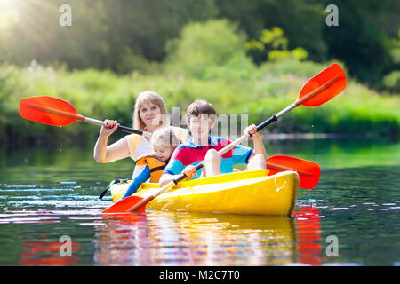 Kind mit Paddel auf Kajak. Sommer Camp für Kinder. Kajak- und Kanufahrten mit Familie. Kinder im Kanu. Little Boy auf Kayak fahren. Wilde Natur und ... Stockfoto