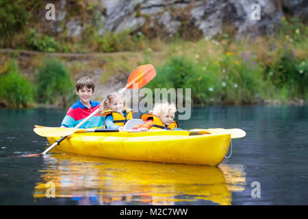 Kind mit Paddel auf Kajak. Sommer Camp für Kinder. Kajak- und Kanufahrten mit Familie. Kinder im Kanu. Little Boy auf Kayak fahren. Wilde Natur und ... Stockfoto