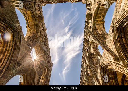 Zu Sonnenlicht durch Torbögen von Whitby Abbey, Whitby, Yorkshire, UK peaking Stockfoto