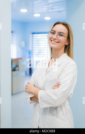 Glücklich lächelnde fröhlicher junger Arzt Frau im Büro Stockfoto